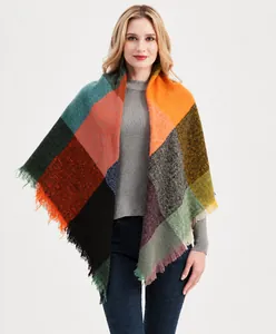 Détail d'un châle à carreaux multicolores avec motifs orange et bords à franges
