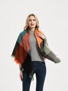Détail d'une grande écharpe à carreaux doux avec motifs color-block et bords à franges