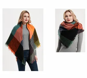 Gros plan sur l'écharpe en maille épaisse à carreaux orange, vert et bleu avec franges