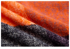 Macro texture of thick orange and grey plaid scarf showing soft brushed fabric detail