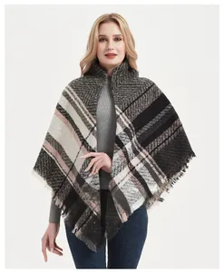 Close-up of thick fishbone pattern knit fabric with tassel fringe on women's winter shawl