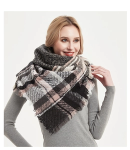 Detail of soft thick scarf with classic grey pink plaid pattern and frayed fringe edges