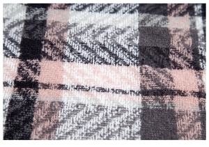 Macro shot of pink, white, and grey herringbone weave fabric texture on winter scarf