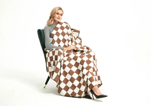 Detail of the soft brown and white checkered knit blanket with fine edge stitching