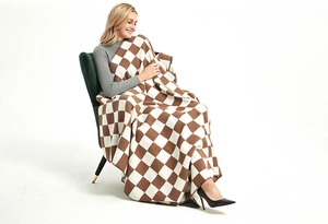Close-up of brown and white checkered knit throw blanket on a green armchair
