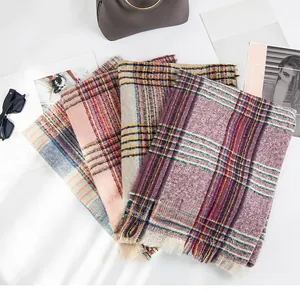 Flat lay of colorful checkered knit scarves with fringe detail and fashion accessories