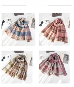 Detail view of four colorful plaid scarves with fringe edges and soft bouclé texture