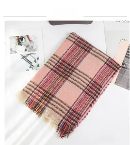 Detail view of pink plaid scarf featuring soft knit texture and delicate fringe edges