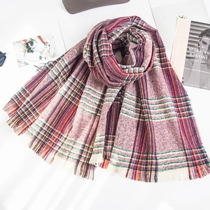 Detail of soft purple plaid scarf with multicolor stripes and fringe on white bedding