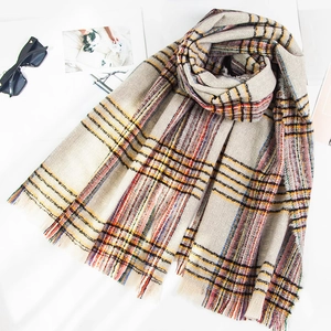 Detail of colorful plaid scarf with soft fringe edges and textured loop yarn fabric