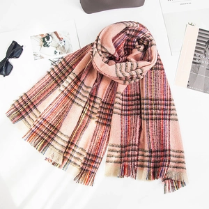 Detail of colorful plaid scarf with soft knit texture and multi-color fringe tassels