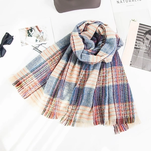 Detail of colorful plaid scarf fabric texture with soft tassels and woven fringe