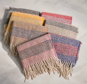 Detail of colorful striped knitted scarves with fringe tassels in various winter colors