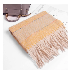 Detail of soft ginger striped knit scarf with thick fringes and warm winter texture