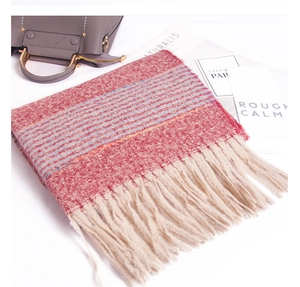 Detail of soft knit scarf with red white stripes and fringe on a minimalist background