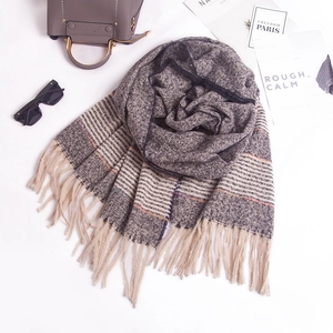 Detailed close-up of striped knit scarf with fringes, grey and beige soft texture