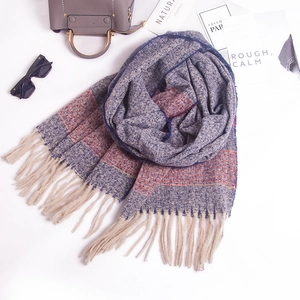 Detail of soft striped knit scarf with beige fringe tassels and fashionable city style