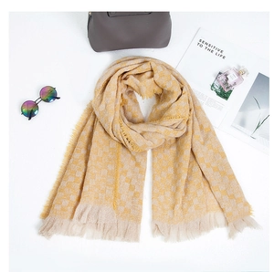 Dettaglio di sciarpa a scacchi gialla e beige con frange e accessori alla moda