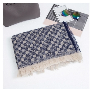 Dettaglio di una sciarpa in maglia a scacchi con nappe e motivi blu navy eleganti