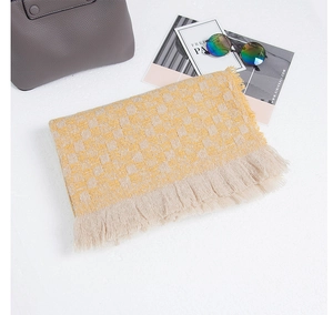 Piatto di scialle a quadri beige giallo con frange, borsa grigia e occhiali da sole