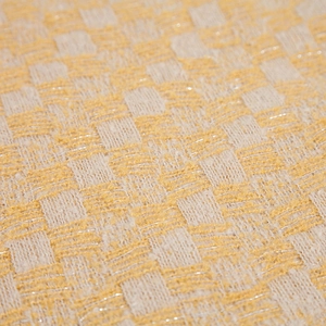Primo piano del tessuto a scacchi giallo e bianco con fili metallici argentati scintillanti