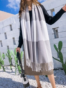 Détail de l'écharpe à carreaux gris et blanc avec franges élégantes en cachemire
