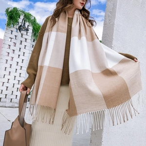 Détail d'une écharpe douce à carreaux beige et blanc avec de longues franges élégantes