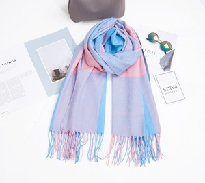 Détail à plat d'une écharpe pashmina à carreaux rose et bleu avec des franges élégantes