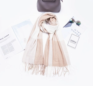 Détail d'une écharpe douce à rayures beiges et blanches avec franges et accessoires de mode