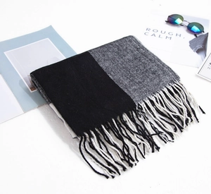 Détail d'une écharpe à carreaux noir et gris avec finitions élégantes à franges