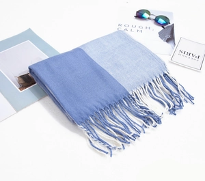 Détail d'une écharpe à carreaux bleu marine et bleu clair avec franges et accessoires