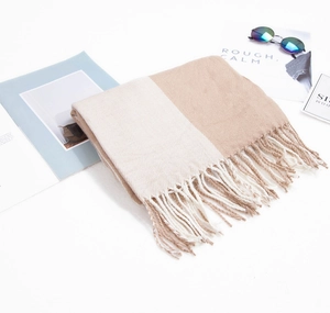 Gros plan détaillé sur l'écharpe bicolore beige et kaki avec franges douces