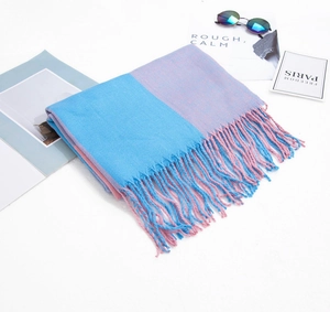 Détail d'une écharpe bicolore bleu et rose avec des franges et un motif à carreaux