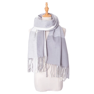 Détail de l'écharpe à carreaux gris et blanc avec texture douce et longues franges
