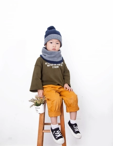 Detail of kids knit hat and scarf set in navy and grey with warm pom-pom accent