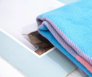 Détail du motif à chevrons bleu et rose montrant la texture douce du tricot cachemire