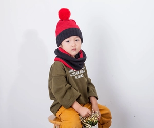 Detail shot of kids thick knit beanie with red pompom and matching neck warmer scarf