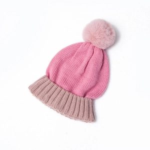 Winter knit hat with a pink pom-pom and contrasting color block design for kids