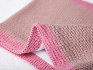 Close-up of thick knitted scarf with warm fleece lining and pink striped trim details