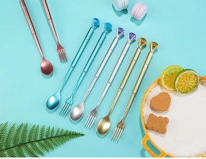 Close-up of cutlery-shaped pens with colorful gems on a bright blue background