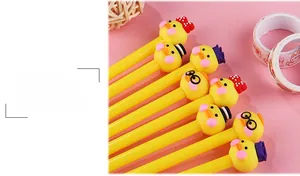 Detail of four cute yellow duck toppers on 0.5mm black ink pens over pink background