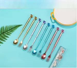 Macro shot of creative cutlery-shaped pens with colorful gemstones on a blue background
