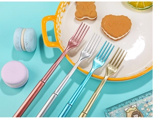 Detail of creative cutlery-shaped pens in metallic pink, silver, blue, and gold finishes