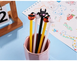 Close-up of Halloween pumpkin, ghost and bat pens in a pink marble holder
