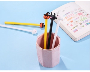 Halloween cartoon pumpkin bat ghost pens set displayed in a pink marble pen holder