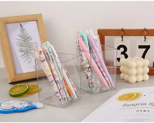 Détail de porte-stylos en acrylique transparent avec papeterie sur bureau en bois