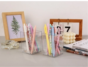 Détail de porte-stylos carrés en acrylique transparent avec fournitures scolaires
