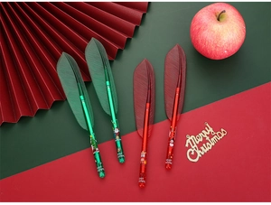 Close-up of Christmas feather pens with festive leaf caps and holiday cartoon prints