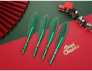 Close-up of four Christmas leaf pens with Santa and reindeer patterns in festive setting
