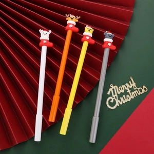Close-up of four Christmas themed gel pens with silicone cartoon toppers and festive props